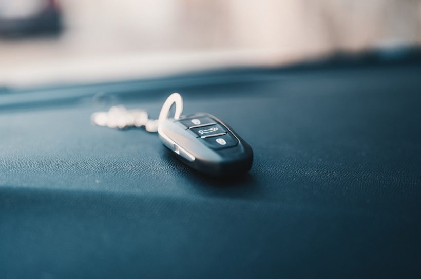 Close-up of a car key fob resting on a dashboard