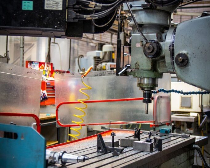 Close-up of a manufacturing machine with various components showing cutting tools and control systems