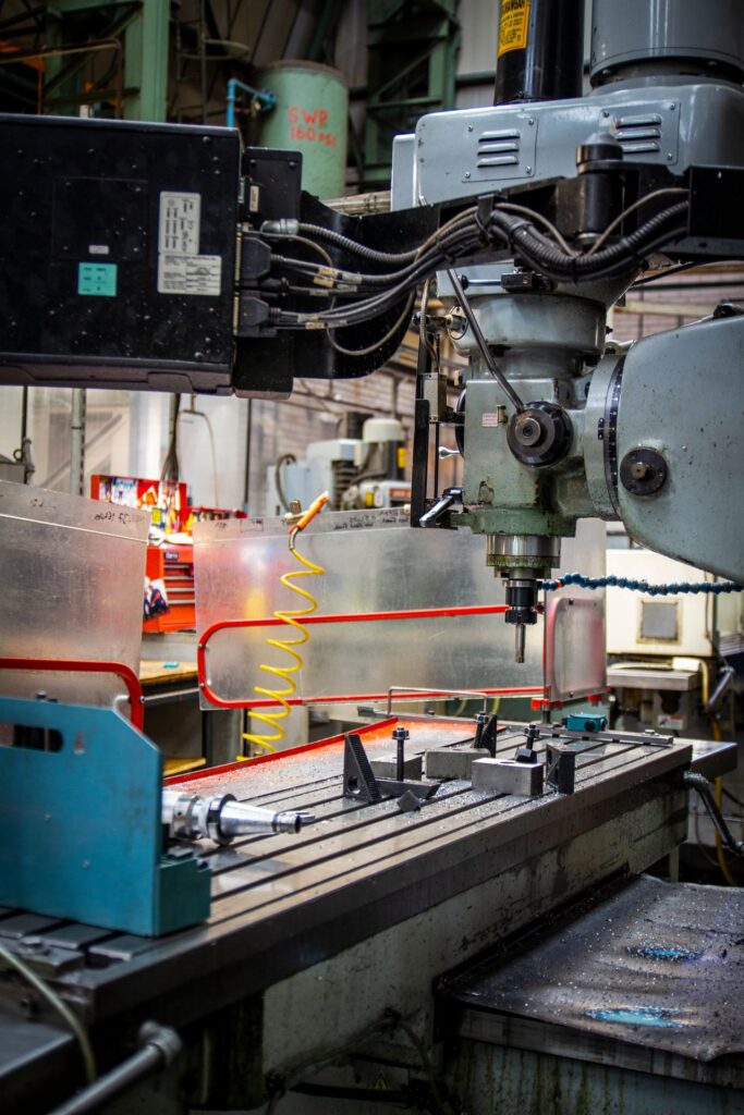 Close-up of a manufacturing machine with various components showing cutting tools and control systems